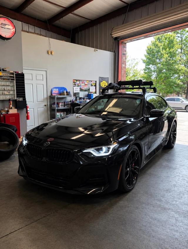 Black BMW 2 Series coupe parked in the German Performance bay with the shop door open